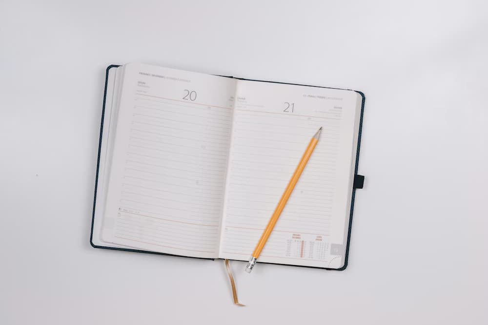 A detailed view of a notebook and pencil, illustrating our meticulous manual auditing and data tracking process for mattress durability.